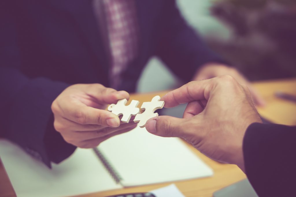 Zwei Menschen stecken Puzzelteile zusammen symbolisch